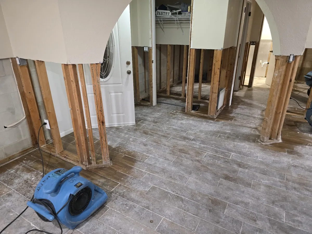 Air movers drying a room after wet drywall was cut out to the studs