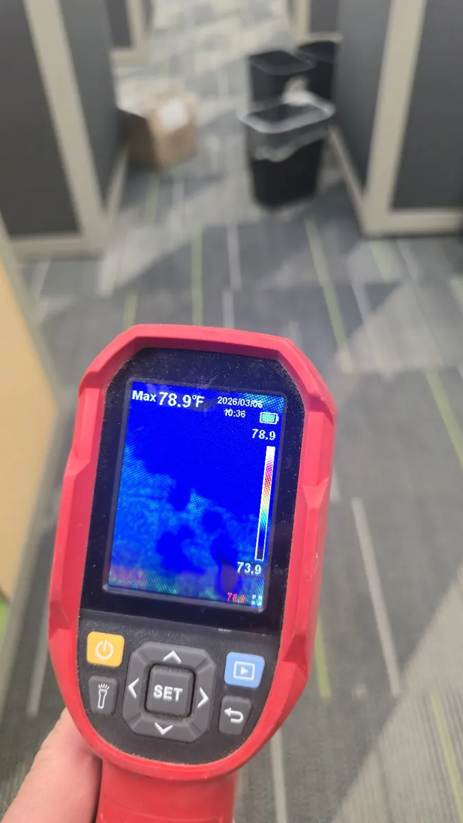 Thermal imaging camera showing a moisture reading on a wet floor
